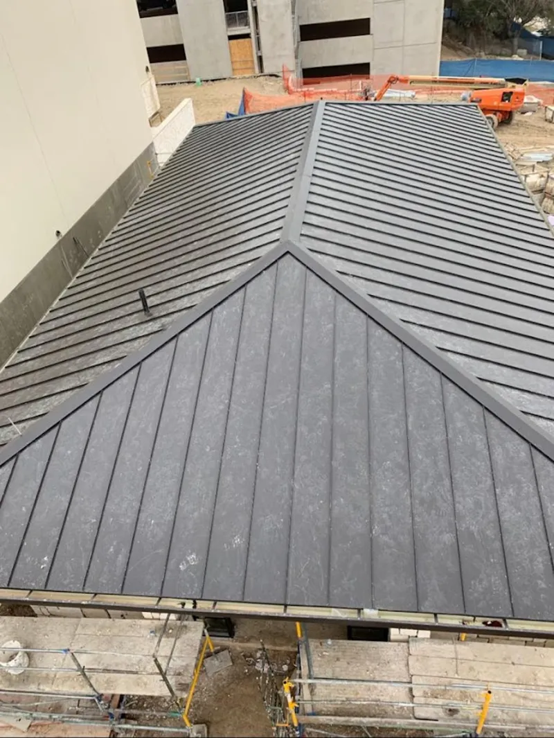 Commercial metal roof construction with crane equipment in Crawford